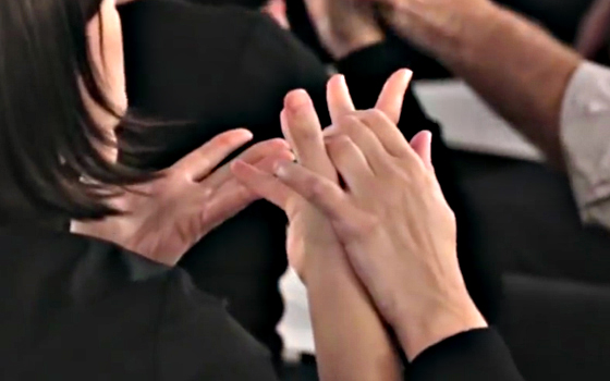 Fotografia che mostra come si posizionano le mani se si usa la lingua dei segni tattile con una persona sordocieca esperta